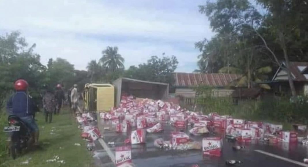 A lorry overturns in Indonesia, carrying beer.